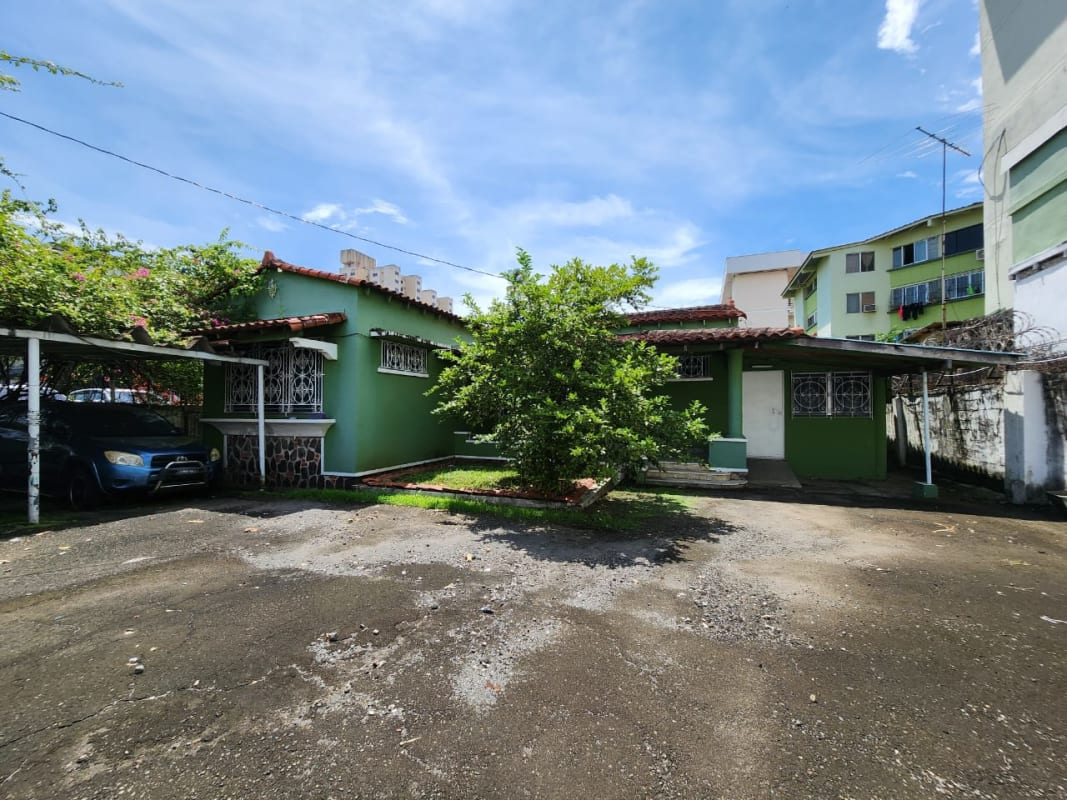 Front exterior of single-story green house with tiled roof Parque Lefevre Panama City