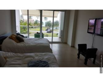 Minimalist bedroom with single bed and white walls in Bijao Beach Residence Panama