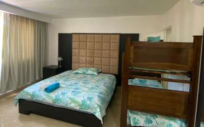 Guest bedroom with closet and ocean view window at Nikki Beach Residences Panama