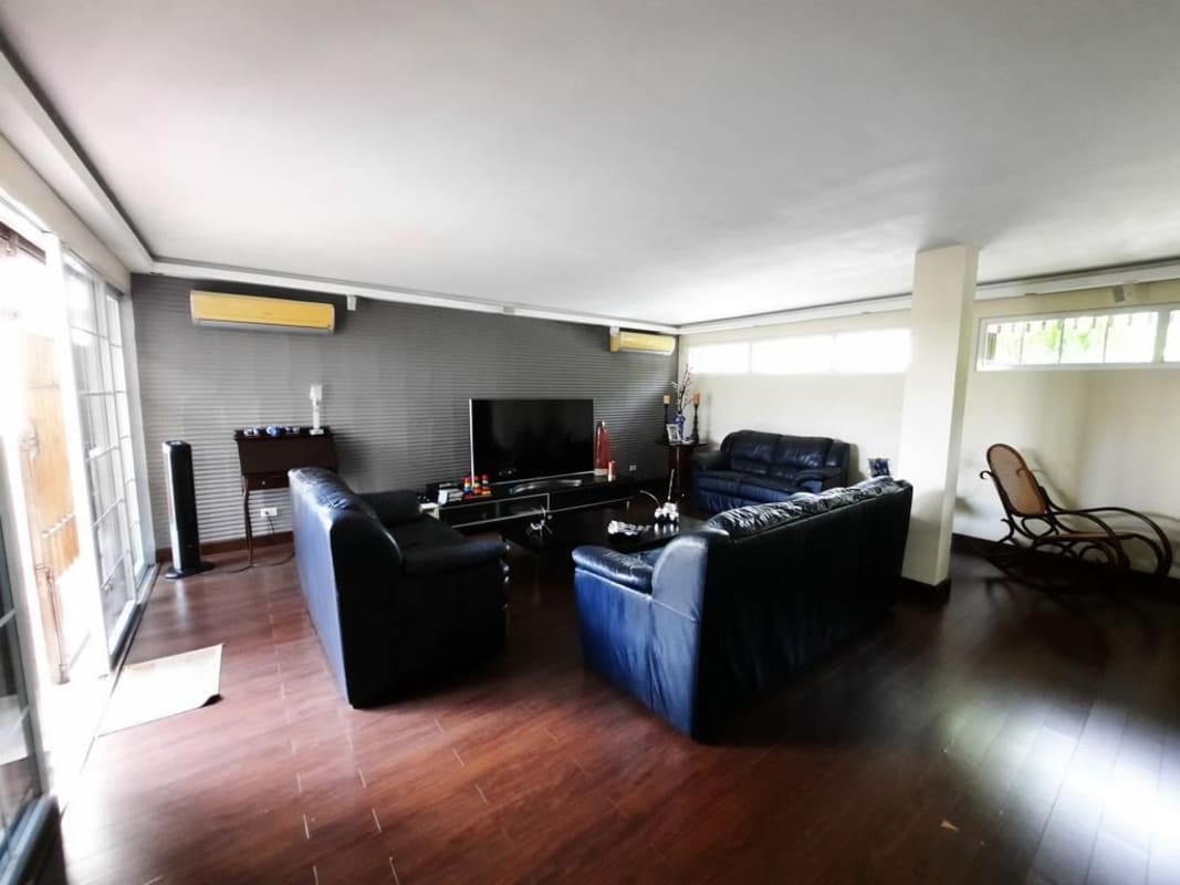 Contemporary living room with AC, large windows, wood flooring in house for sale at La Alameda Panama