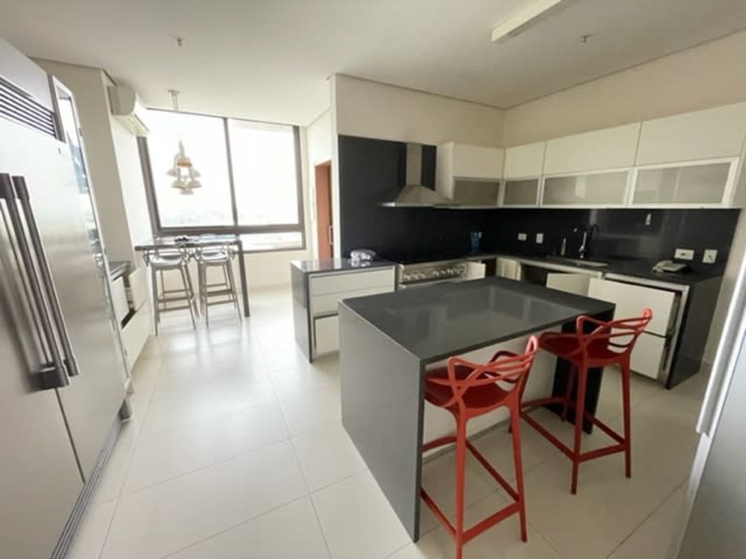 Spacious living room with marble floors, floor-to-ceiling windows featuring golf course and skyline