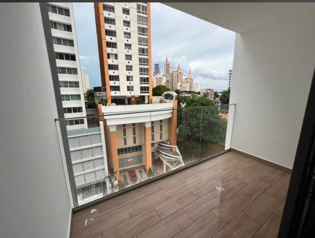 Covered balcony with glass railing and city skyline views in PH Sky Swiss El Cangrejo
