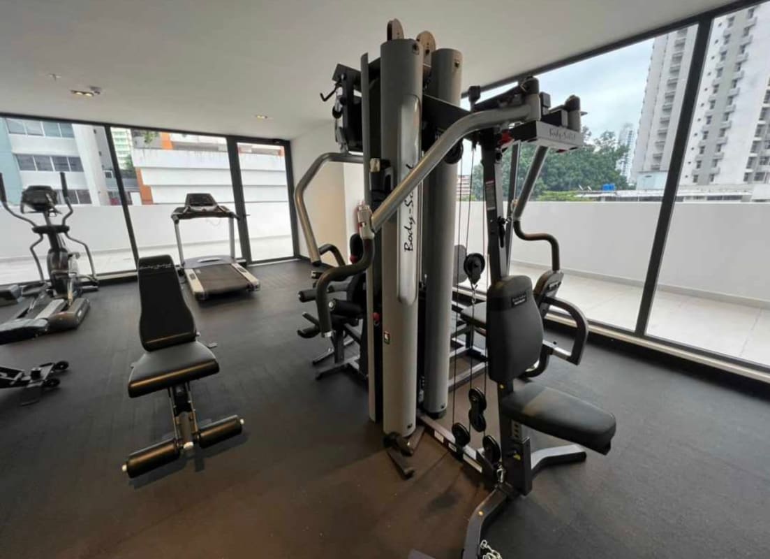 Well-equipped gym with large panoramic windows and city views at PH Sky Swiss Panama City