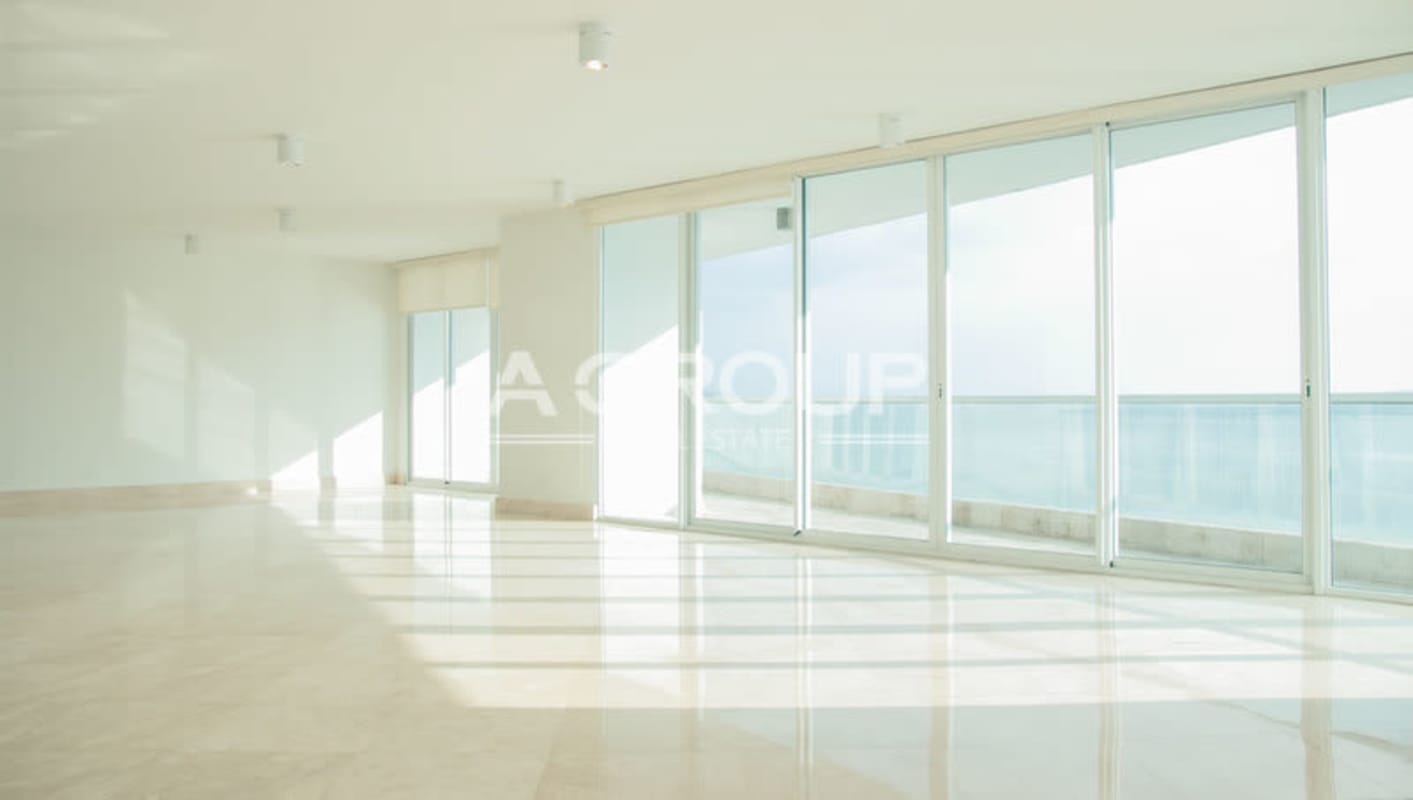 Luxury living area with wrap-around glass ocean views at The Point Tower Panama