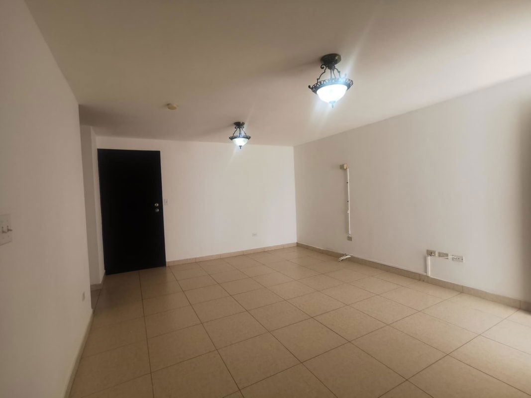 Empty living room with ceramic floors and light from balcony doors at HIP Tower Panama City