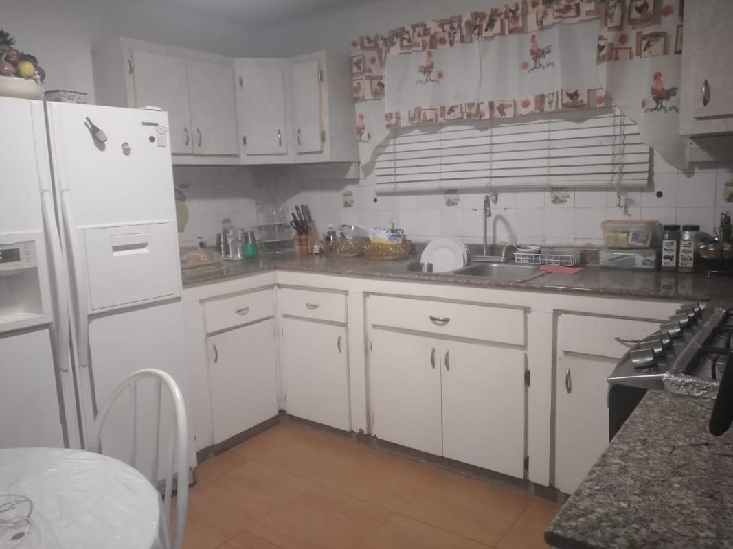 Kitchen with white cabinets granite countertops bright windows house sale Altos de Panamá Panama