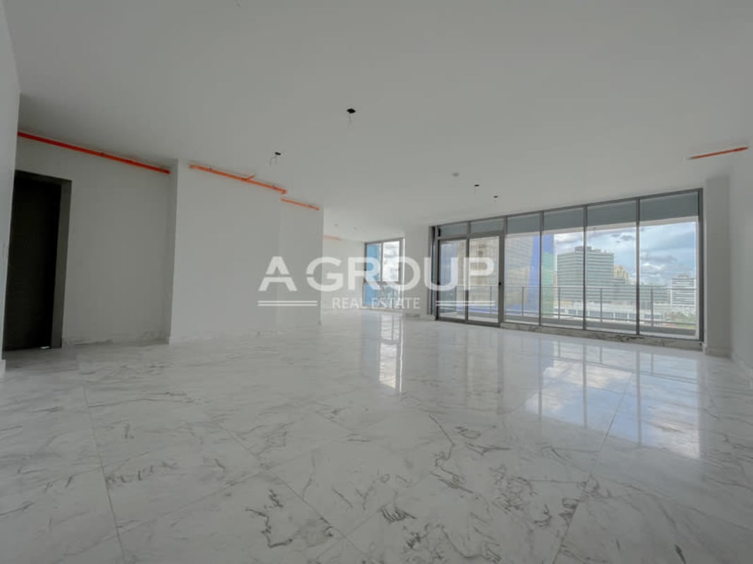 Modern kitchen with island, large window, white cabinetry in luxury condo PH Regalia Costa del Este Panama