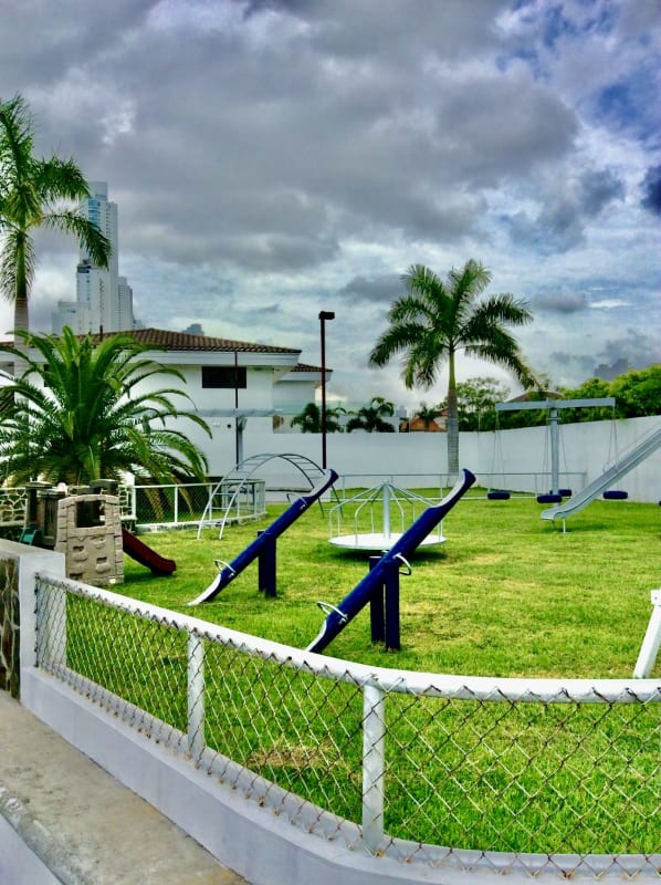 Concrete sidewalk and grass lot facing boundary wall in Costa del Este Panama