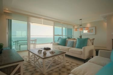 Bright open plan living and dining area with floor-to-ceiling windows, oceanfront views at Playa Blanca