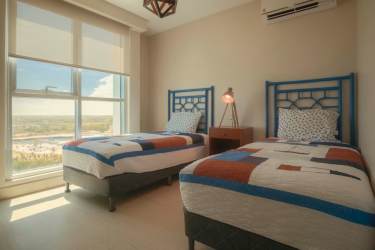 Guest suite bedroom with twin beds, large windows at PH Lighthouse Tower Playa Blanca