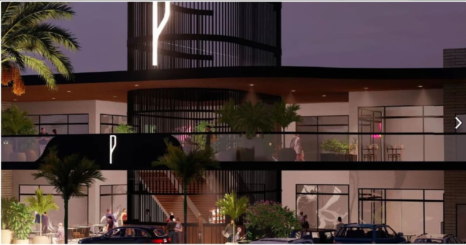 Night exterior of two-story commercial plaza with glass facade illuminated in Brisas del Golf Panama