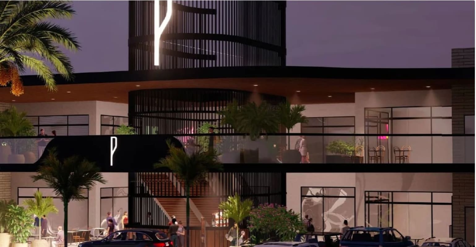 Modern retail space with balconies, glass windows illuminated signage in Plaza Paseo Drive Brisas del Golf