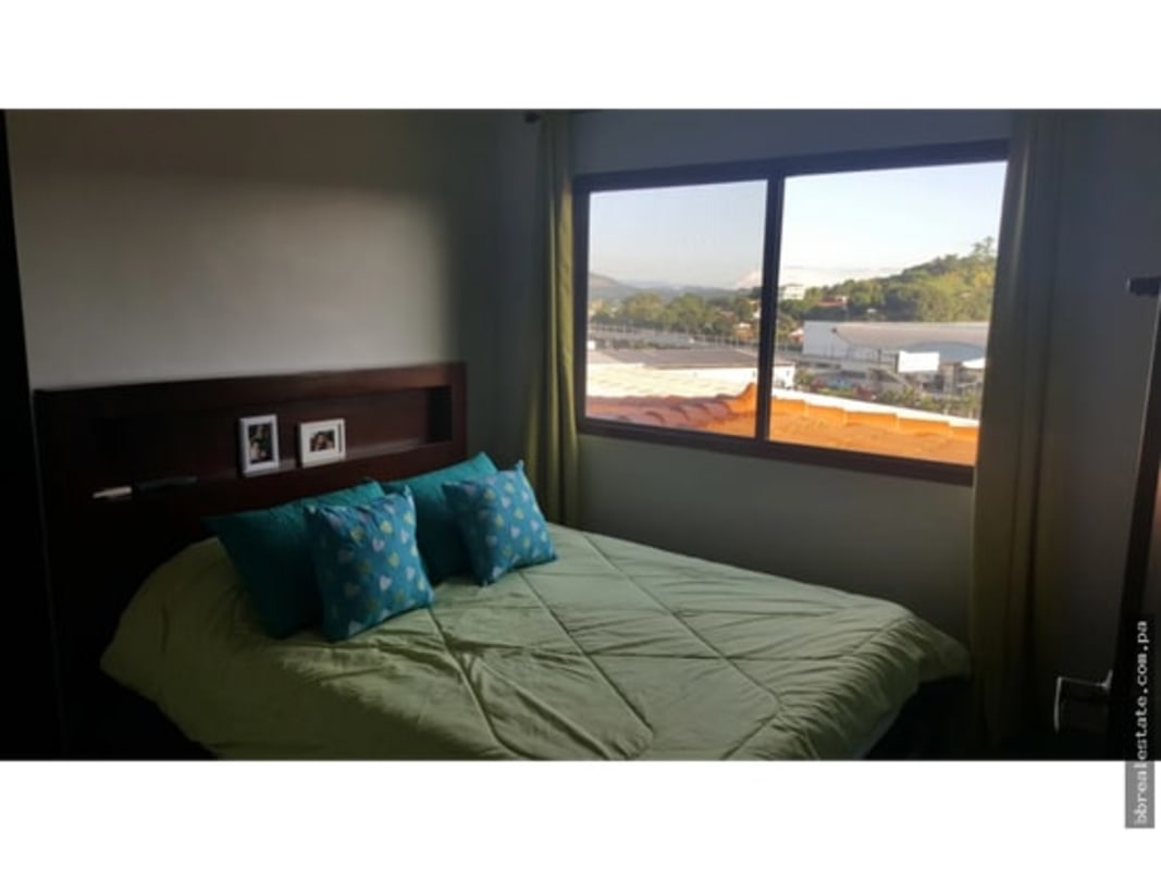 Bedroom interior with big window overlooking nature in Green Villas Las Cumbres Panama