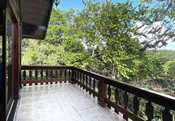 Rustic home office with wood ceilings and large window overlooking garden in Brisas de Los Lagos Panama