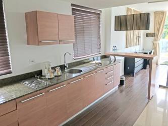 Open modern kitchen with granite countertops and appliances at Playa Blanca beachfront condo Panama