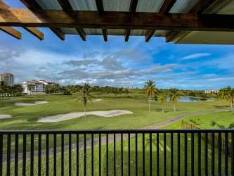 Golf course view with palm trees and blue skies from Vista Mar villa terrace in Panama