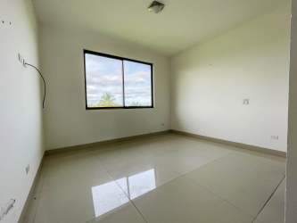 Modern bedroom with glossy tile floor, large window overlooking garden golf Vista Mar Panama