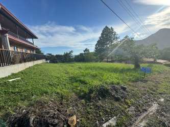 Open grassy lot with adjacent house and mountains at Altos del María La Toscana Panama