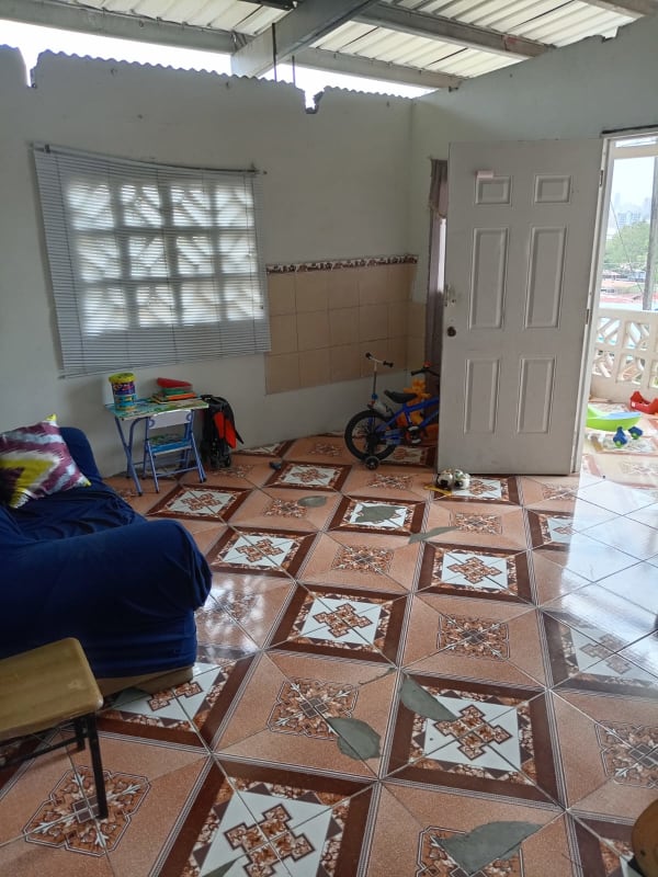Living room with geometric tile floor blue sofa affordable Rio Abajo Panama house