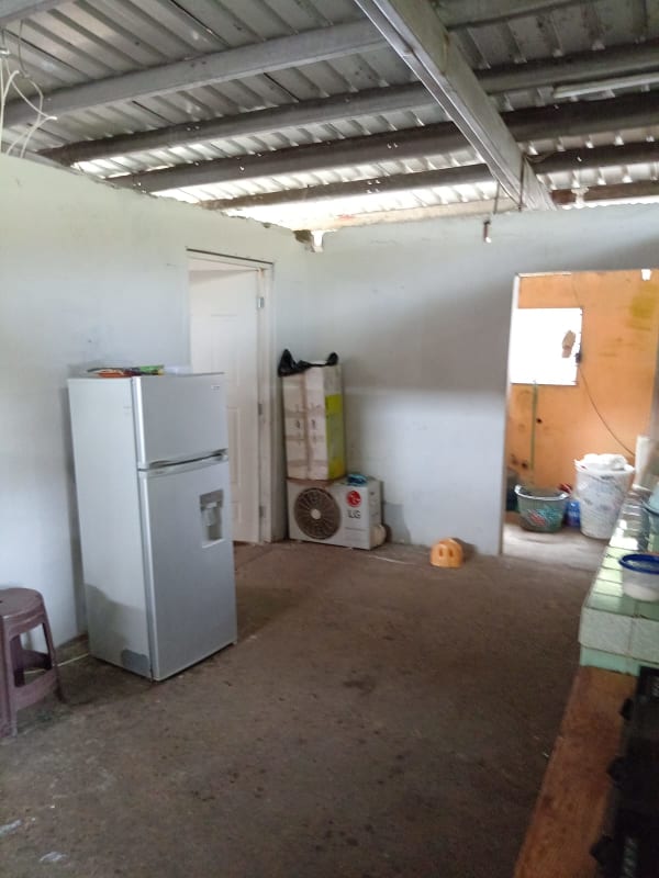 Simple rustic kitchen with exposed metal roof in affordable Rio Abajo Panama house