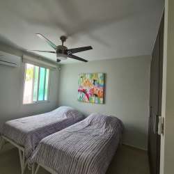 Guest bedroom with two twin beds, ceiling fan, AC and TV in Bijao Rodman condo for sale