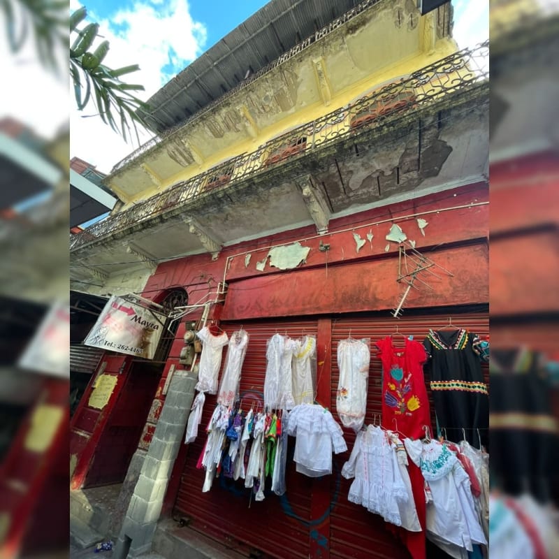 Two story colonial commercial building with retail displays and iron balcony in Panama City