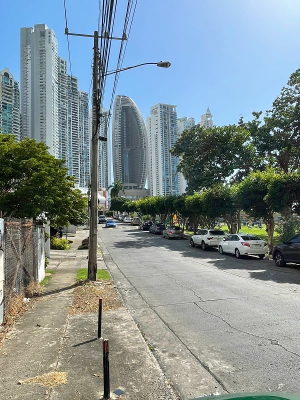 Mix of grass vacant plot and modern residential buildings in prime Panama City neighborhood