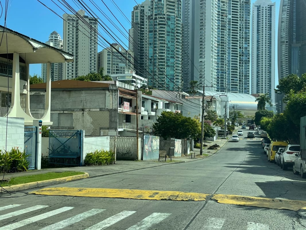 City street lined with mix of towers and gated homes by oceanfront lot for sale Panama