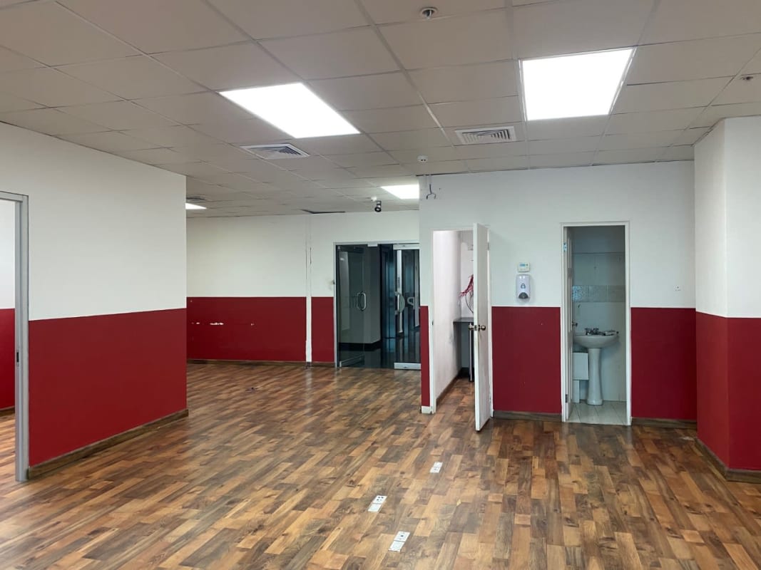 Entrance to empty modern office with wood-pattern floor and glass door at PH Marble Tower Marbella