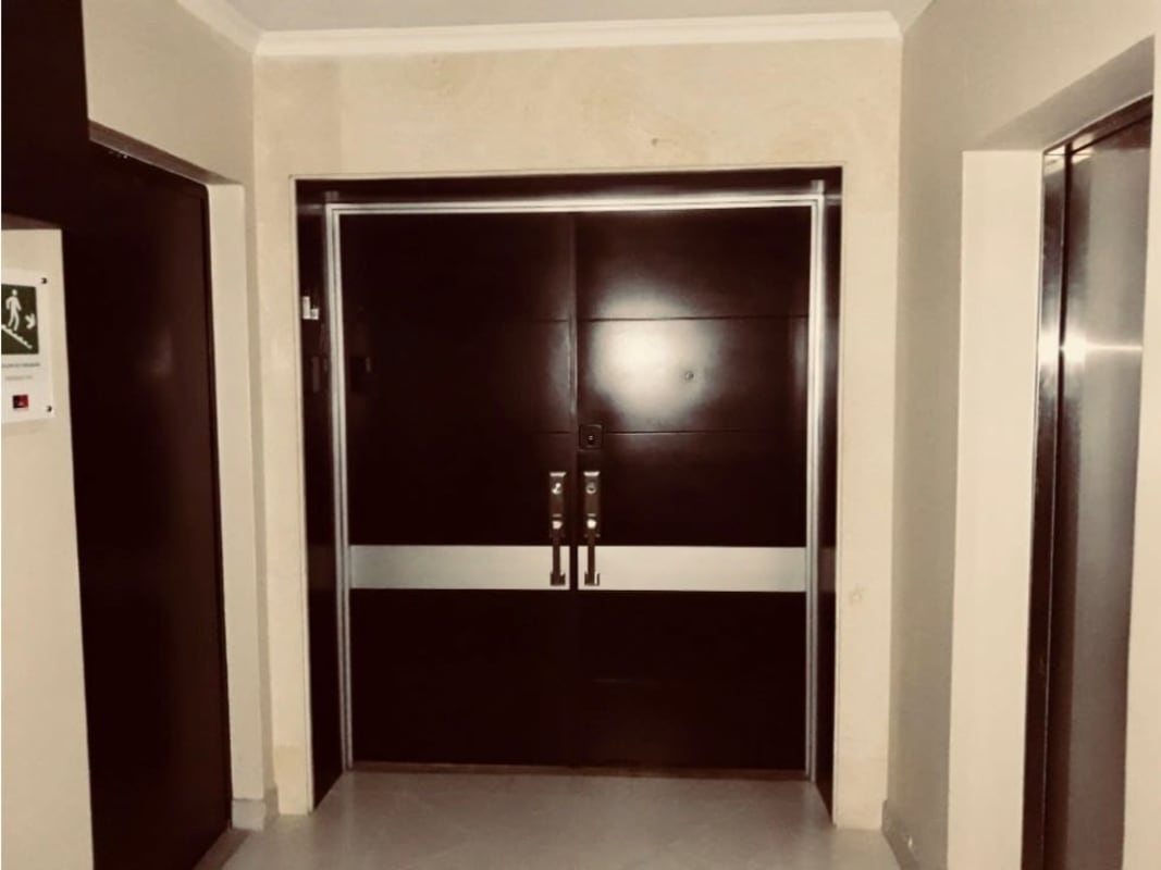 Lobby with double entry doors elevators marble floors in high-rise apartment building Panama City