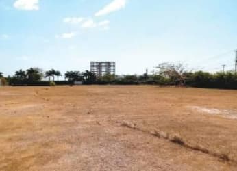 Dry open land lot with distant hotels under blue sky in Playa Blanca Río Hato Panama