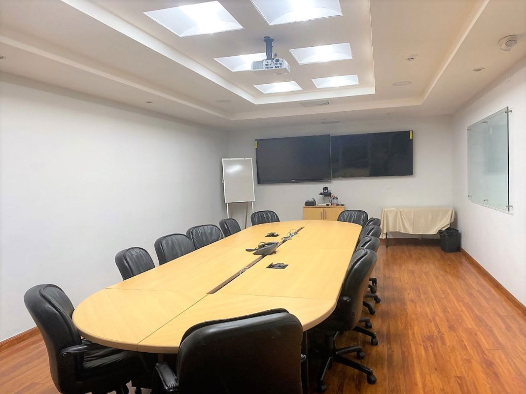 Large boardroom with projector, monitors, oval table in Panama City office