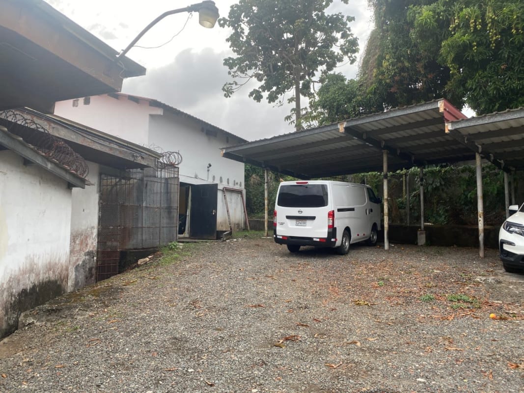 Gravel parking area fenced with metal covers next to commercial building Panama