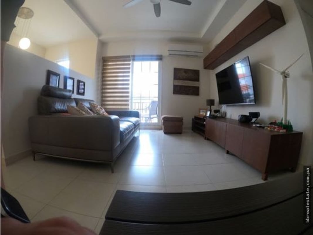 Spacious living room with leather sofa, TV unit, large windows in Costa Sur home