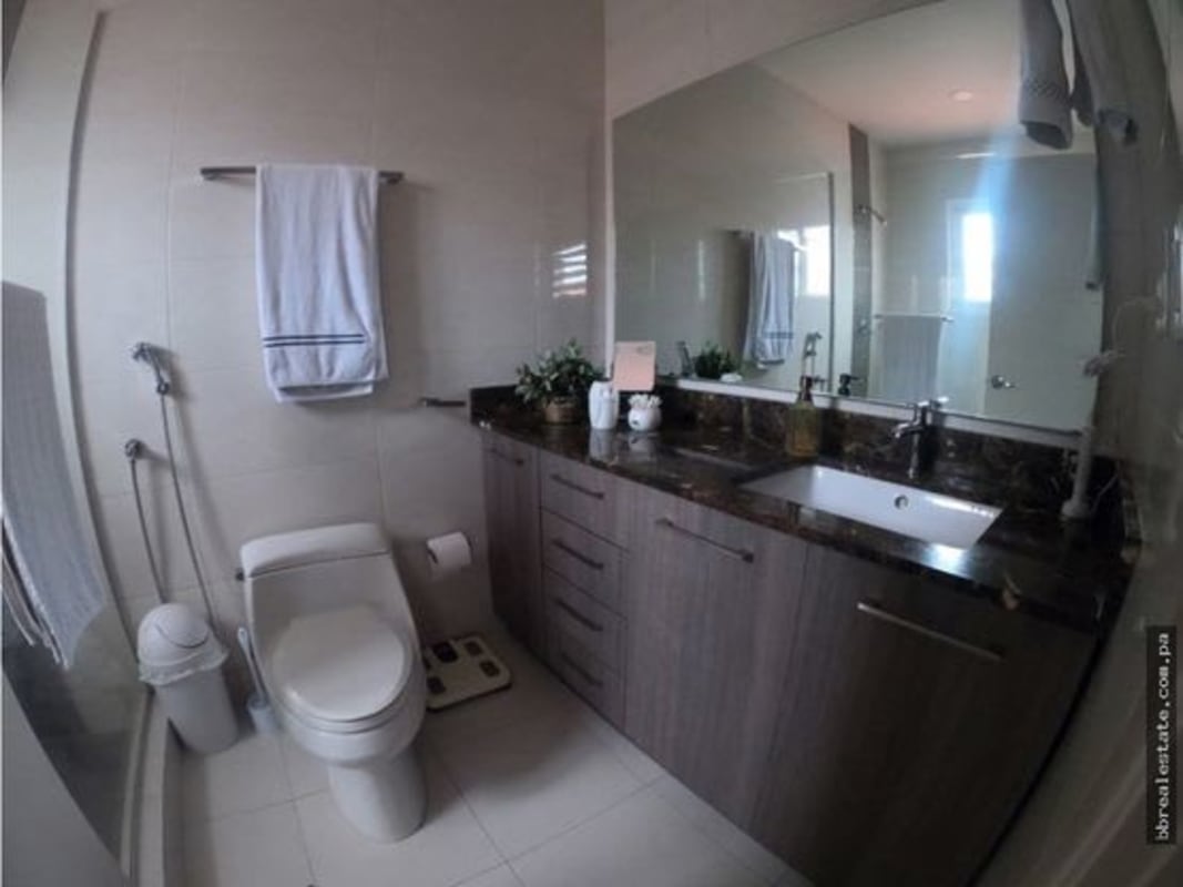 Bathroom with large mirror, marble countertop, and modern fixtures in Costa Sur Panama