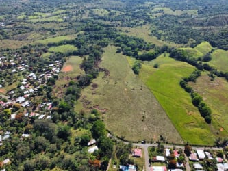 Panoramic aerial countryside view with open fields, hills, and development land near Soná Panama