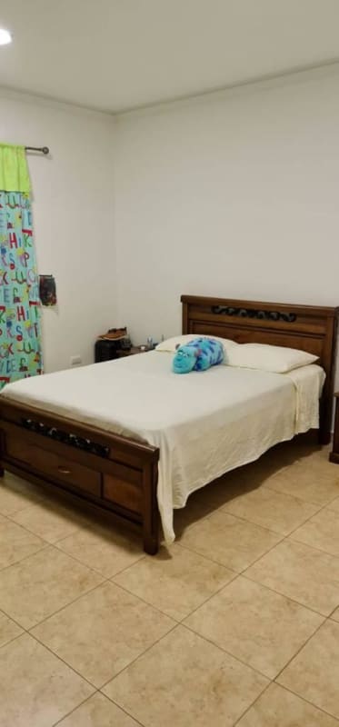 Bedroom with wooden carved bed colorful curtains in Canal Zone house Paraiso Panama