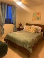 Bedroom with large windows, balcony access and pool views at PH Villa Azul Playa Blanca Panama