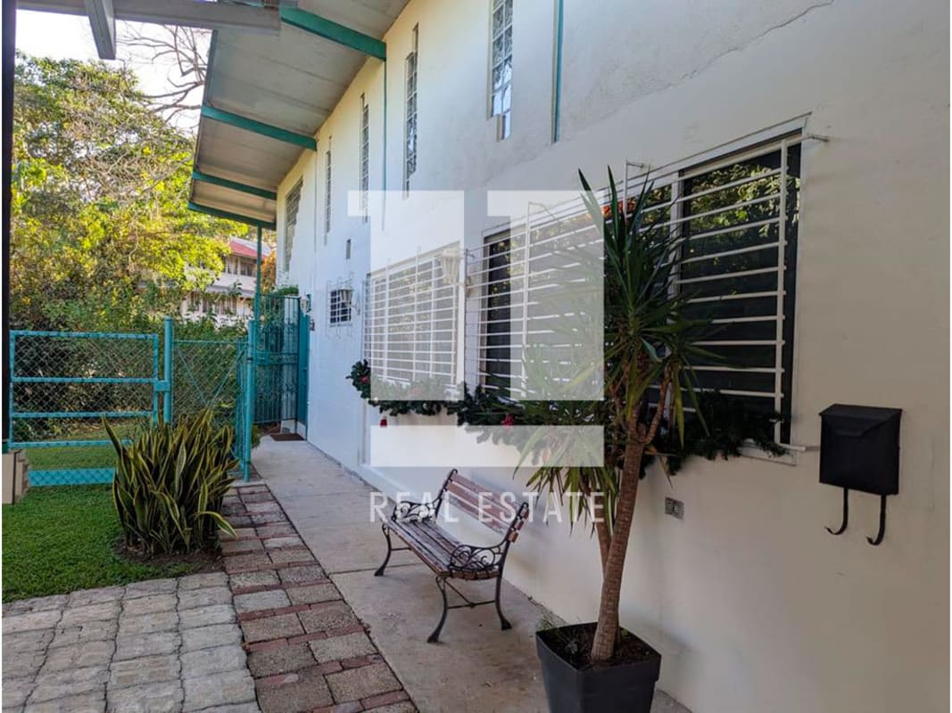 Traditional house facade, decorative windows, turquoise gate, garden, Ancón Panama