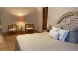 Contemporary bedroom with bed, chairs, and decor Buenaventura Resort Panama