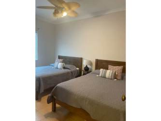 Contemporary bedroom with two beds and ceiling fan at Bristol Residences Buenaventura Panama