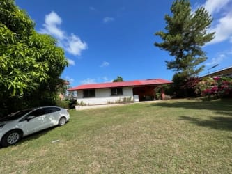 Rustic bright living space with beam ceiling, terracotta floors in Coronado beach house
