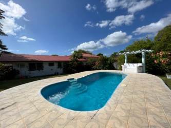 Sunny backyard with swimming pool, pergola, garden at Coronado beach house Panama