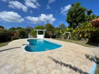 Garden view backyard with swing bench, gazebo, pool, and lush landscaping at Coronado house