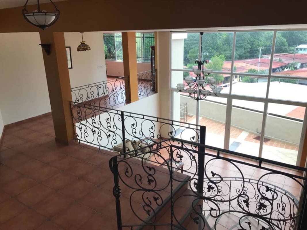 Multi-level living area with metal railing, pendant lighting, high ceilings, and tile flooring Panama