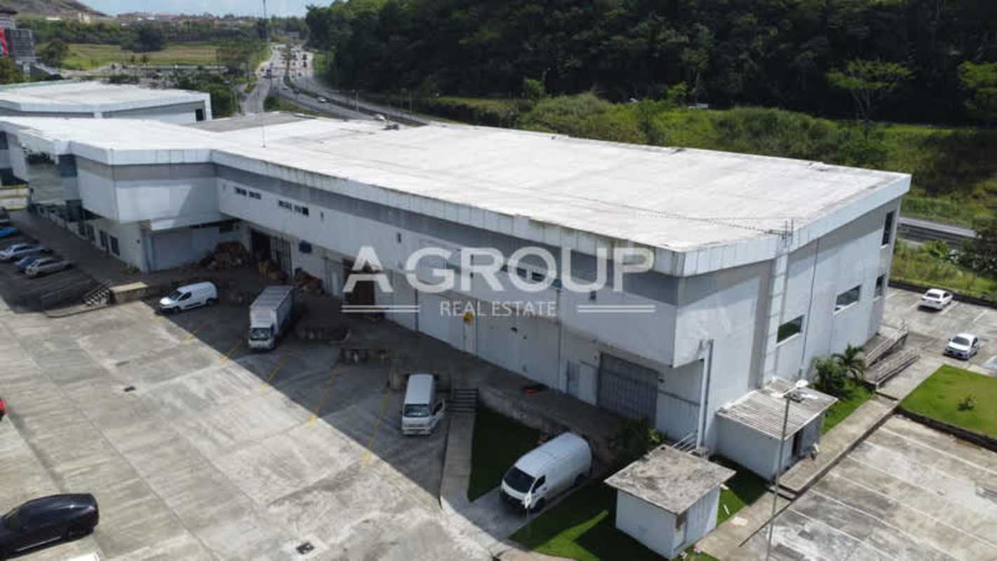 Industrial warehouse with loading bays and delivery trucks at Parque Centenario Panama