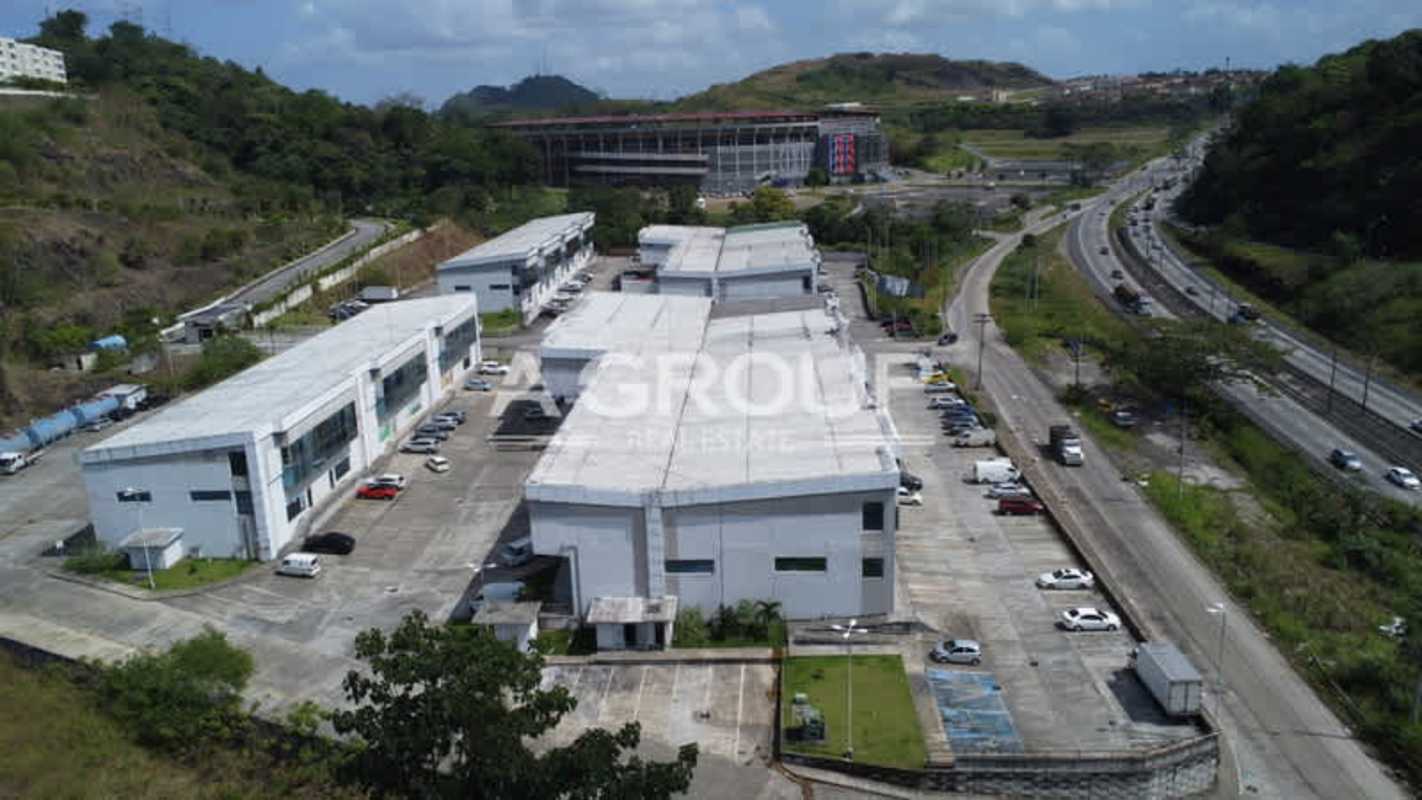 Multi-building warehouse complex with large parking areas near highway at Parque Centenario Panama