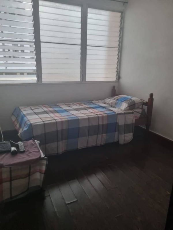 Minimalist bedroom with natural light and wooden floors in El Cangrejo Panama