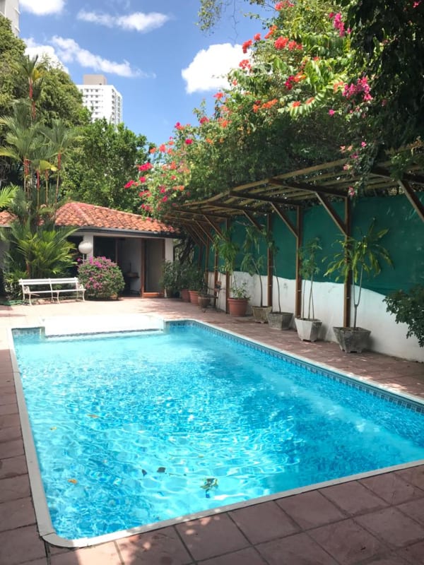 Spacious kitchen with decorative blue tile backsplash and white cabinets in house Altos del Golf Panama