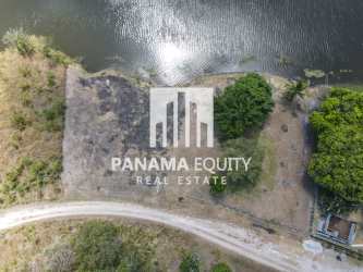Lakefront land with dirt road greenery mountain view aerial Panama